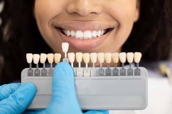 Dentist Choosing Right Emanel Color For Black Female Patient In Clinic